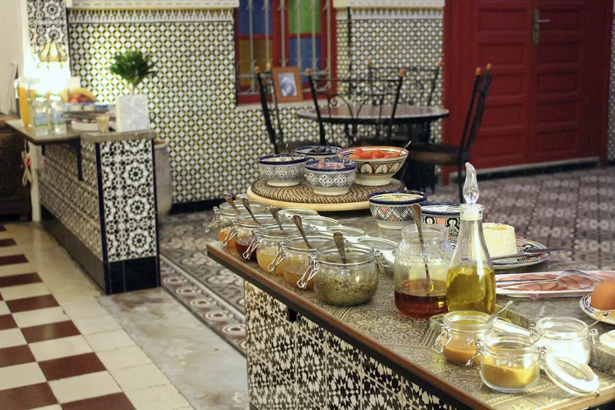 Jars of honey, jam and olive oil on the breakfast counter, a red door behind