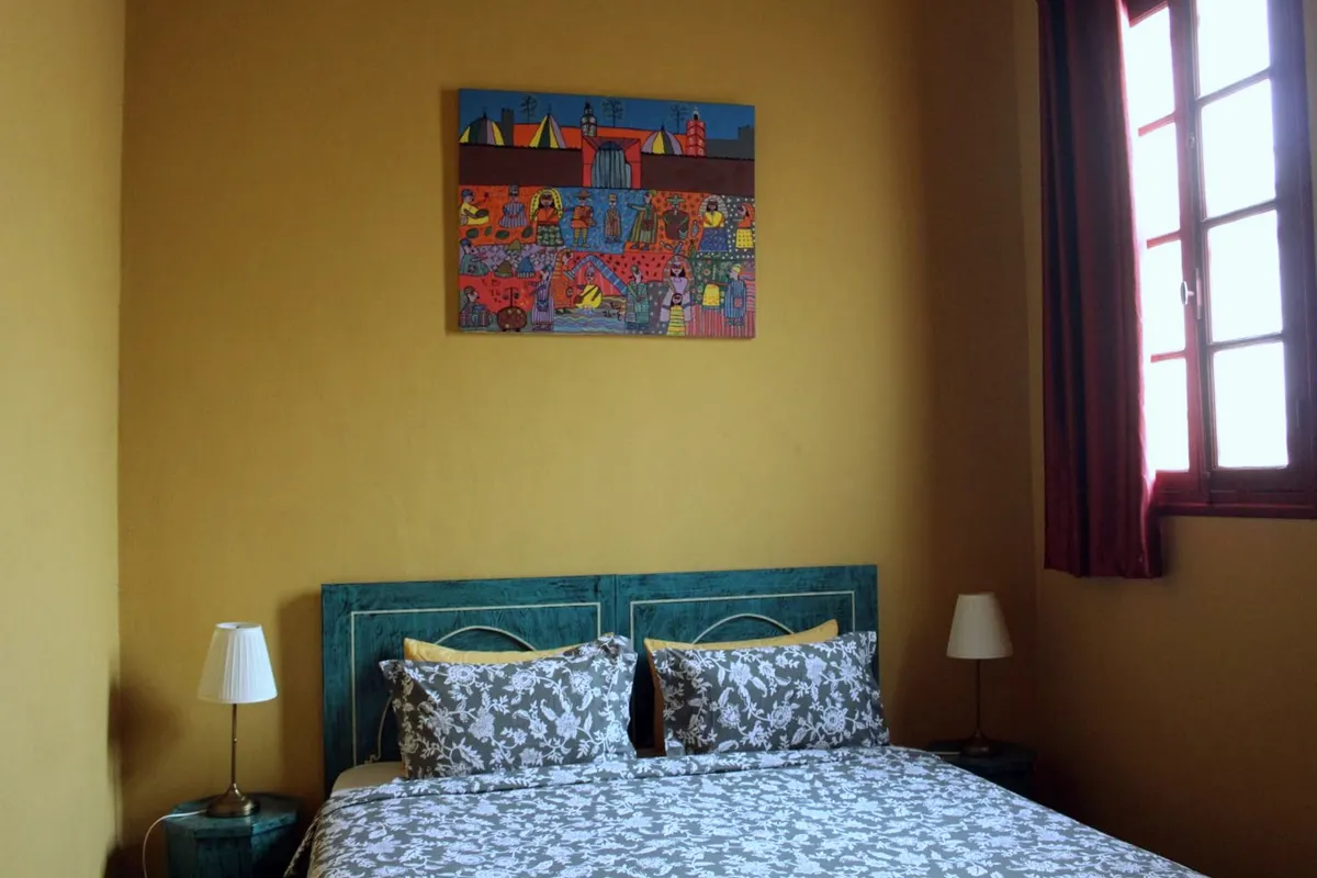 Al Mansour suite: king bed, teal headboard and naive painting