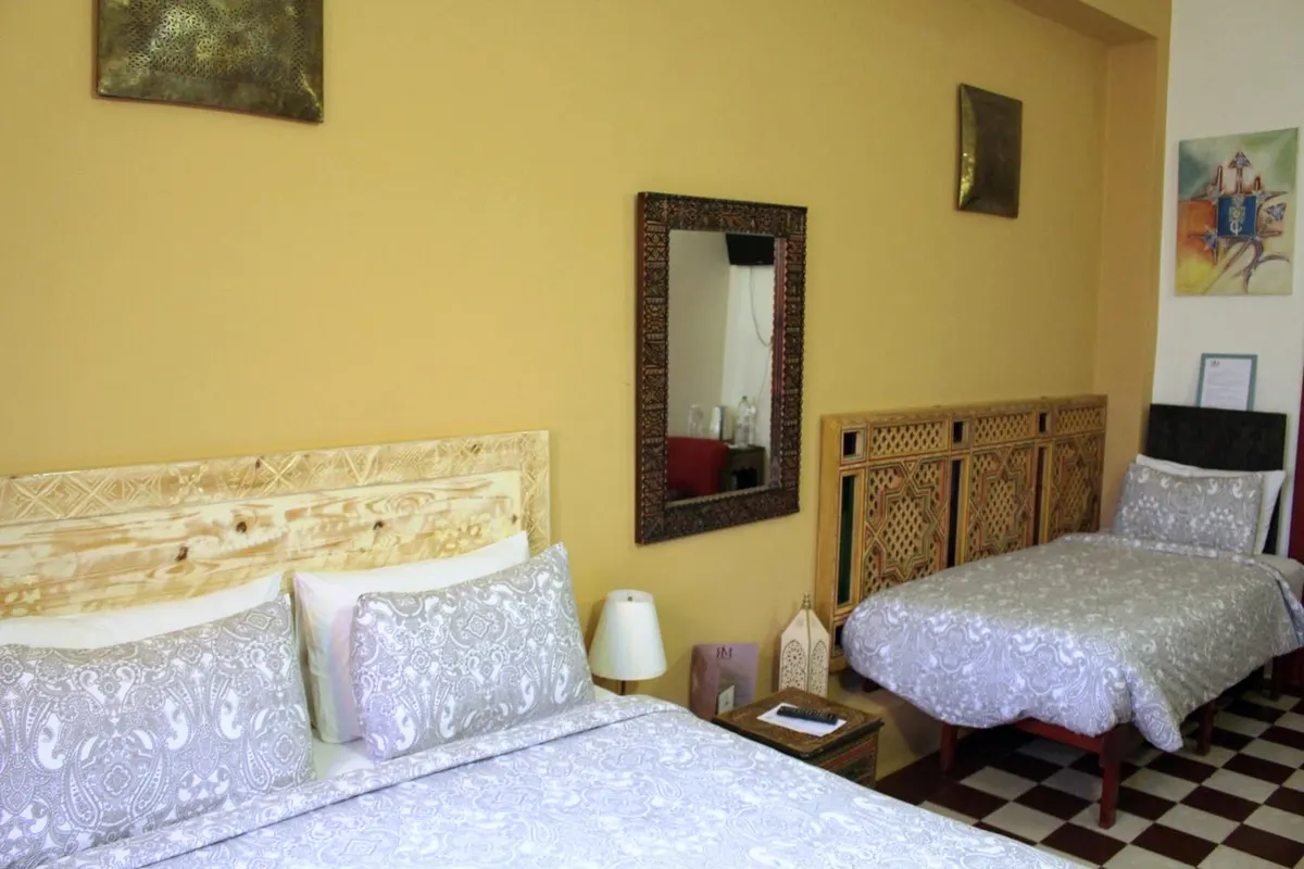 Chambre Bouregreg : lit queen size et lit simple, murs ocre