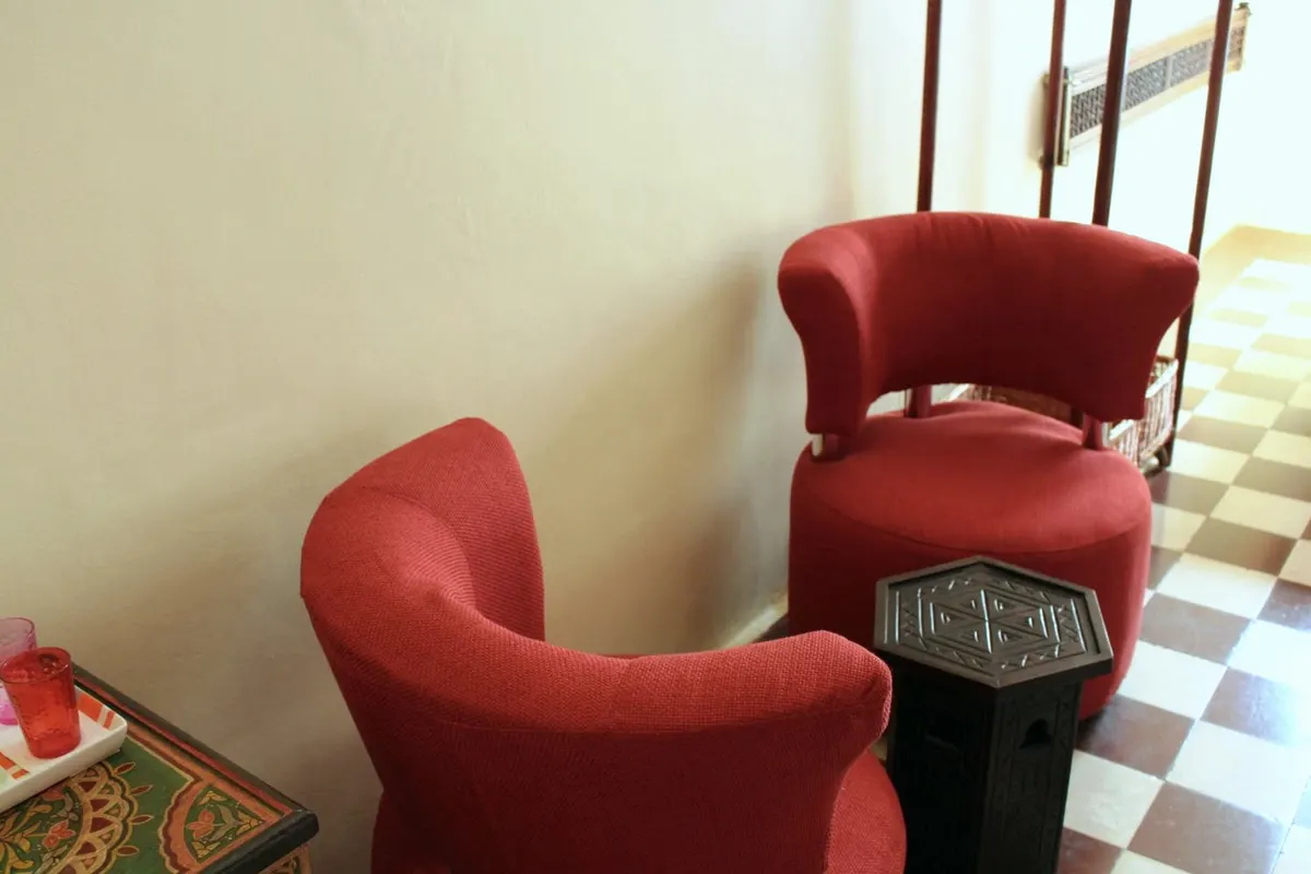 Deux fauteuils de velours rouge sur un sol en damier