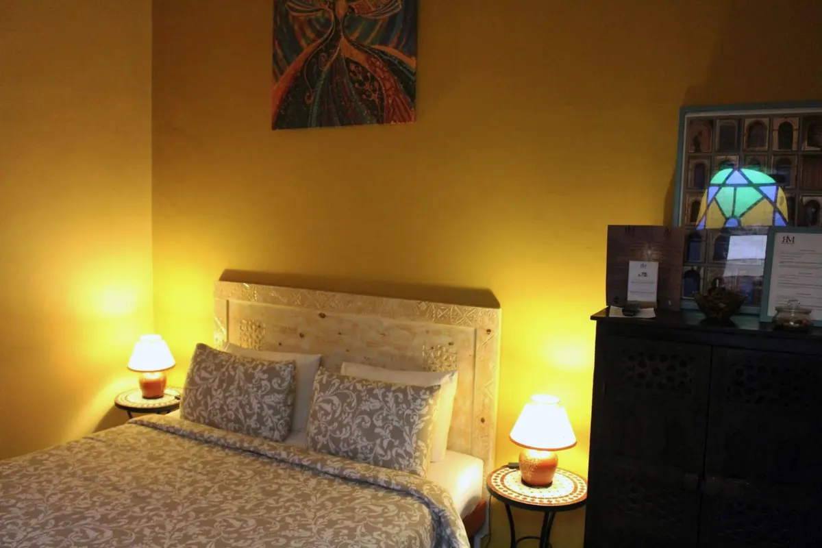 Chellah bed in warm lamplight under a stained-glass lantern