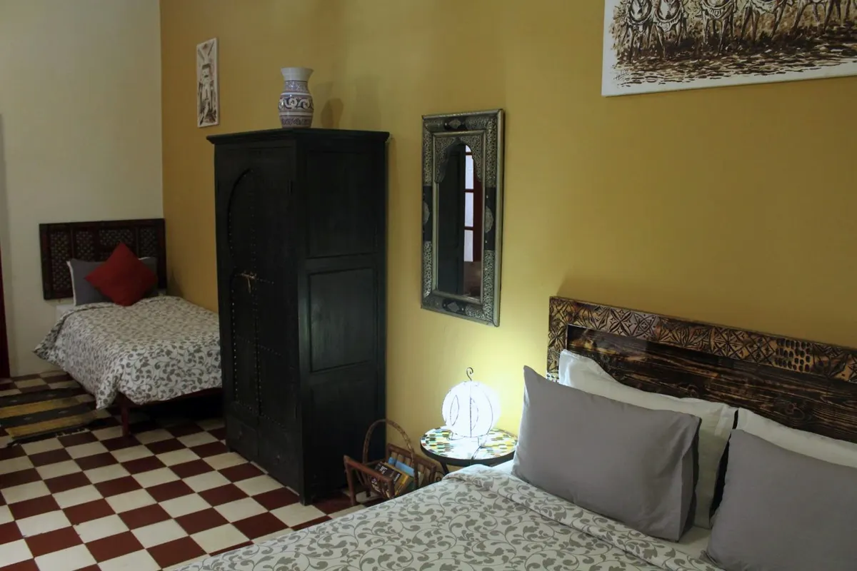 Consuls room with double and single beds on a checkerboard floor