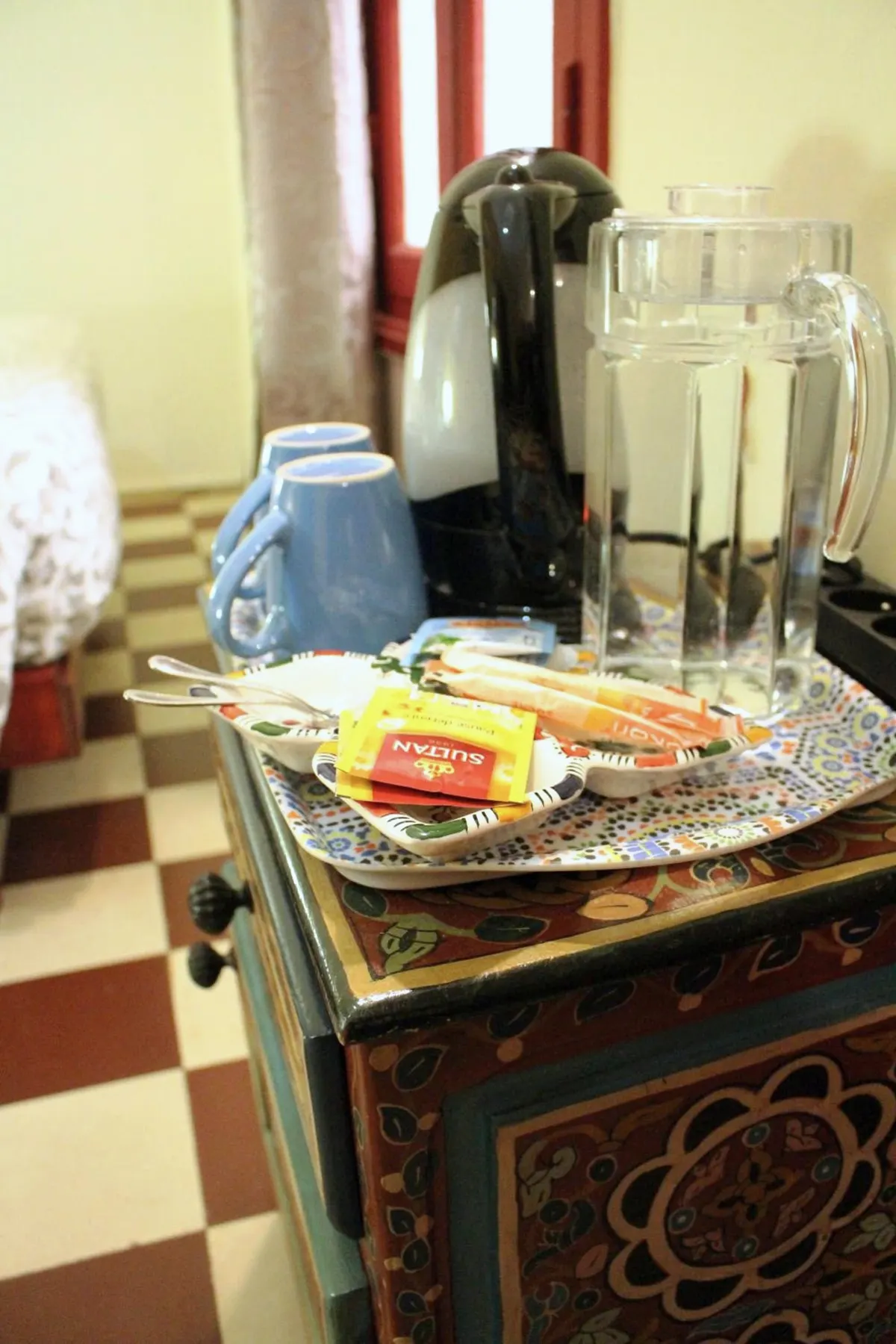 Tea and coffee tray with kettle on a painted chest