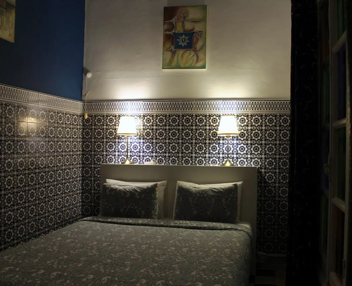 Oudayas room: queen bed against cobalt-and-white zellige
