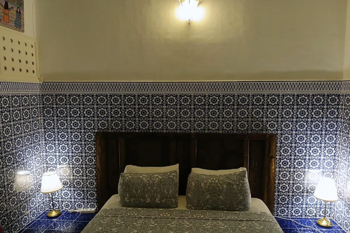 R’Batia bed with wall lamps and blue-white zellige